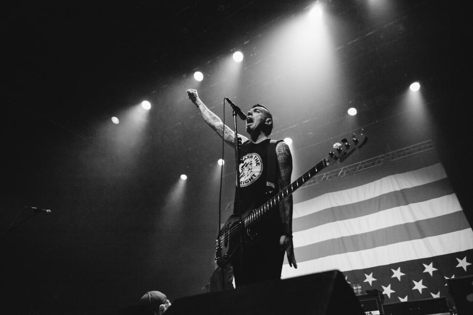 Free Image of Rock musician with blurred American flag backdrop 