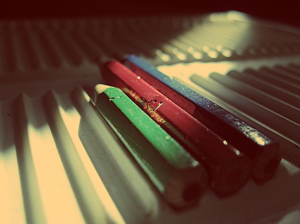 Free Image of Colorful crayons lined up on a sunny sill 