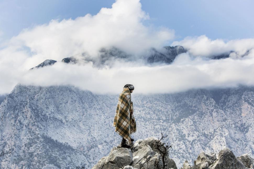 Free Image of Solitary figure facing a sea of mountain clouds 