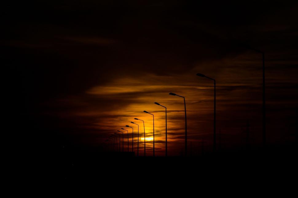 Free Image of Street lights against a dramatic sunset sky 
