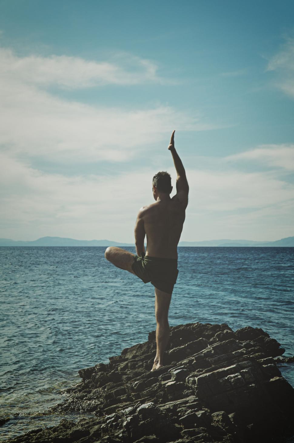 Free Image of Man in yoga pose overlooking the sea 