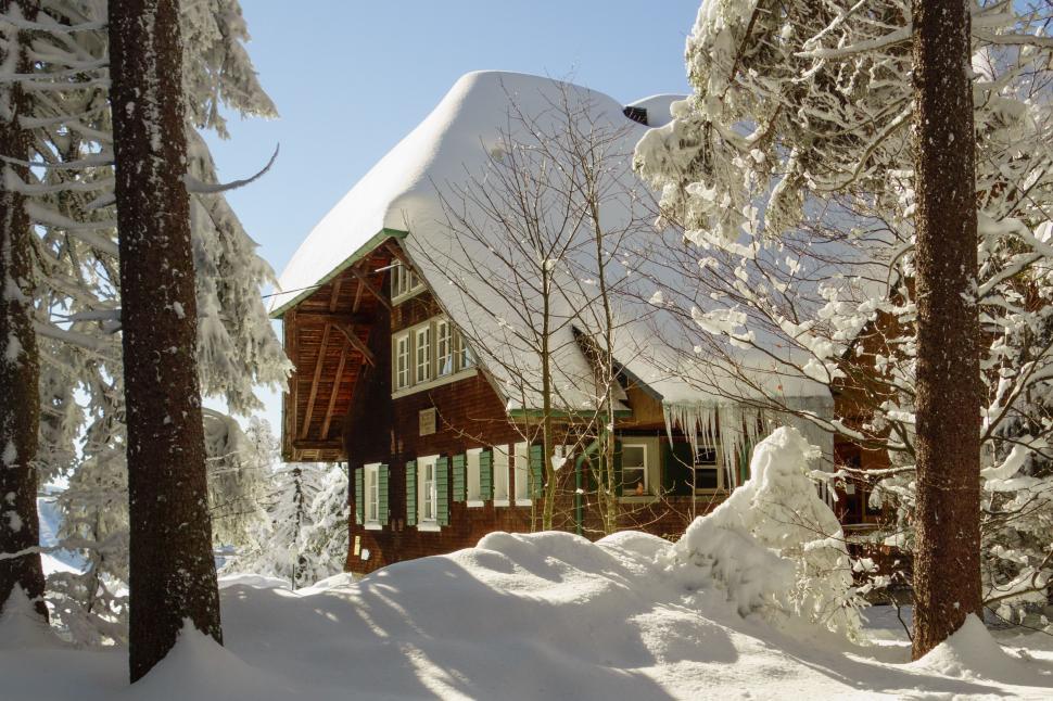 Free Image of Snow-covered chalet amidst a winter forest 