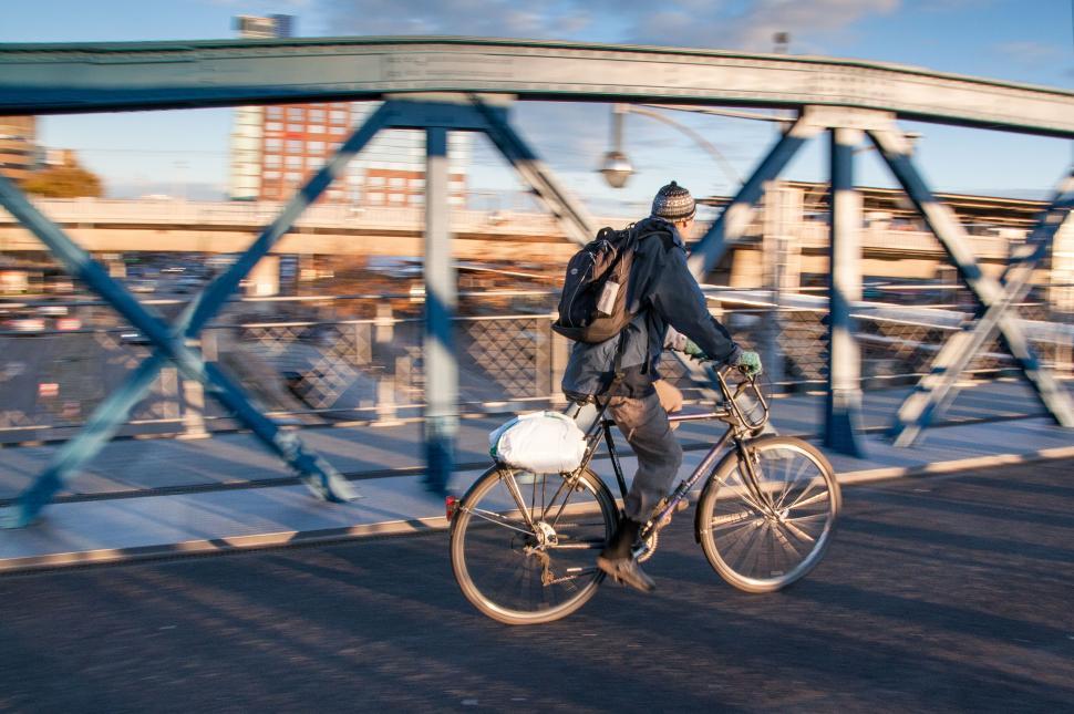 Free Image of Cyclist crossing bridge in motion on sunny day 