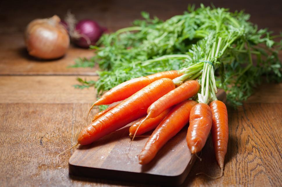 Free Image of Fresh carrots on wooden cutting board 