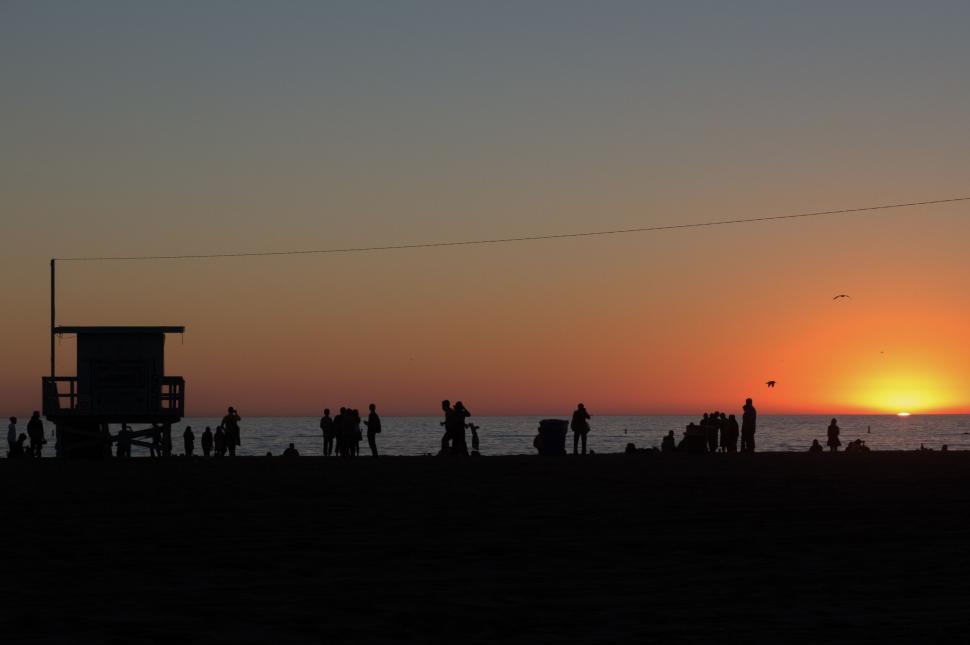 Free Image of Silhouette of people on beach at sunset 
