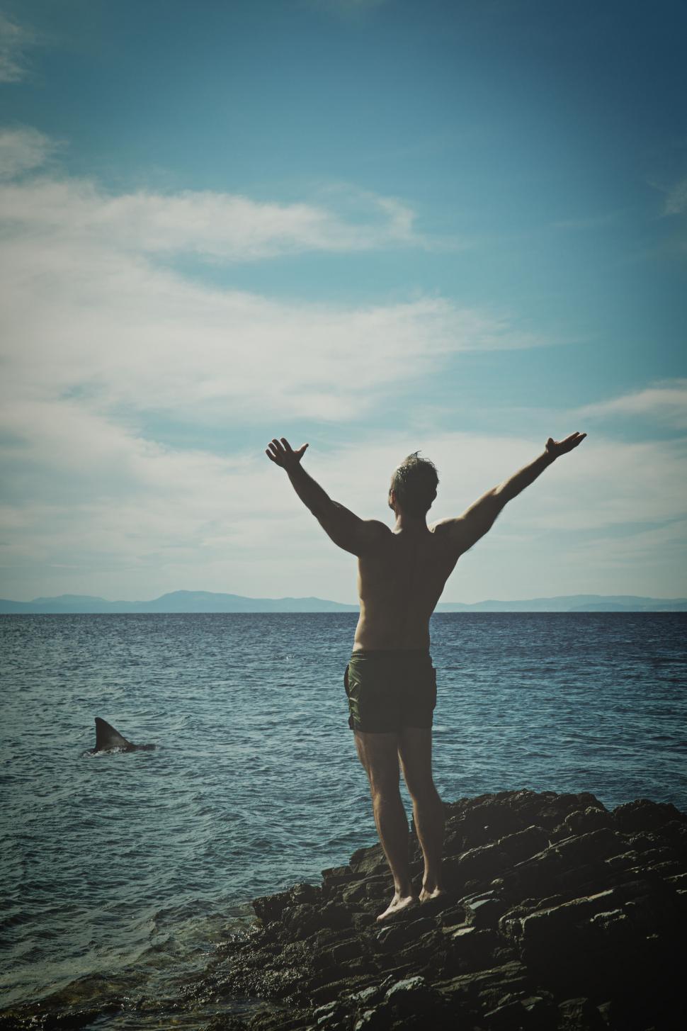 Free Image of Silhouette of man raising arms towards sea 