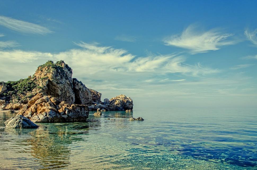 Free Image of Calm seascape with rocky outcrops and clear sky 