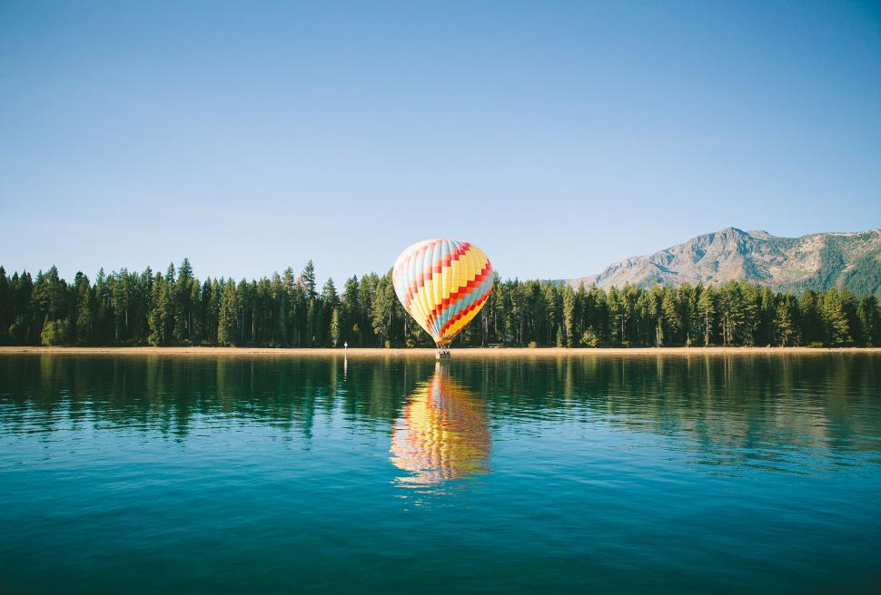 Free Image of Hot air balloon reflection on a serene lake 