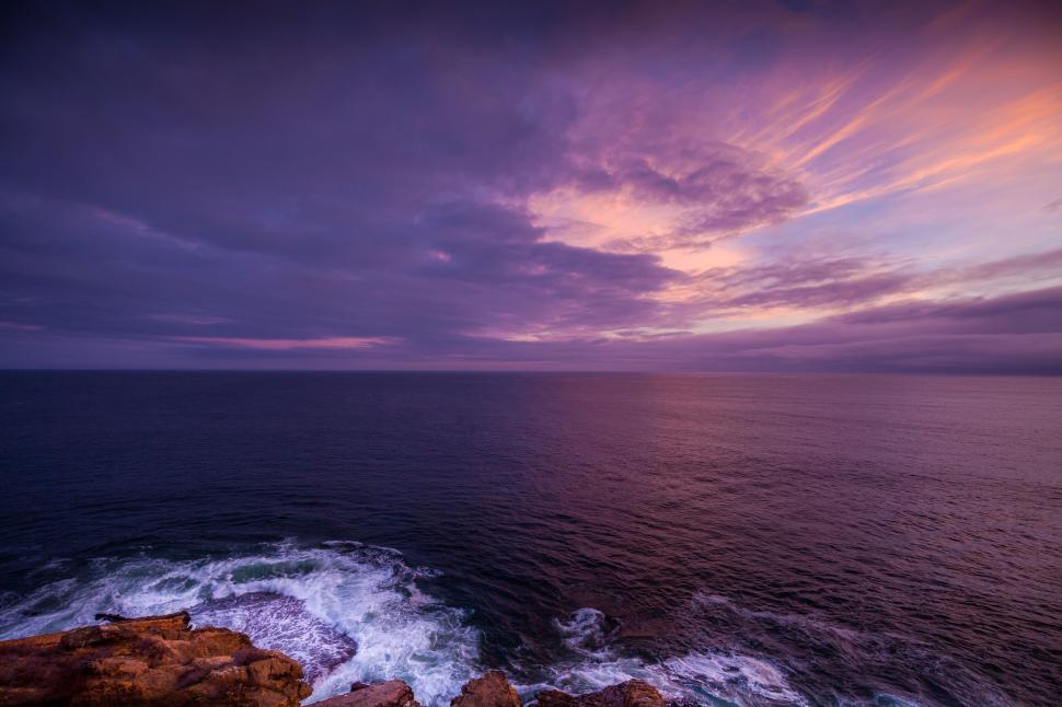 Free Image of Dramatic sunset over a rugged coastline 