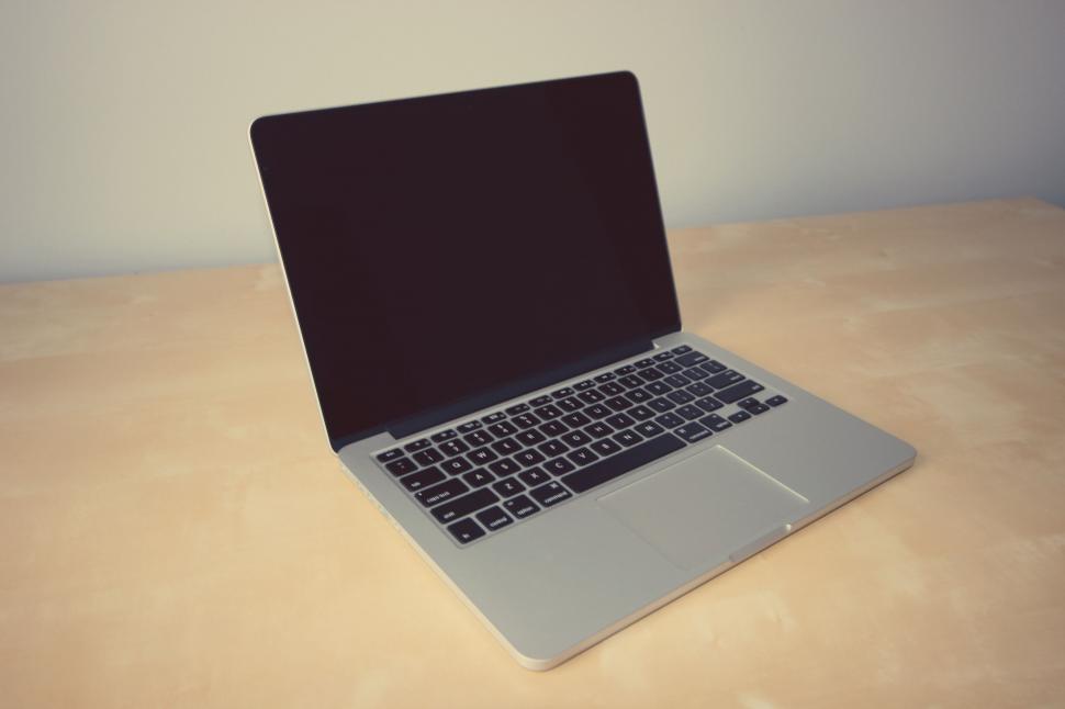 Free Image of Closed laptop on a wooden surface in a room 