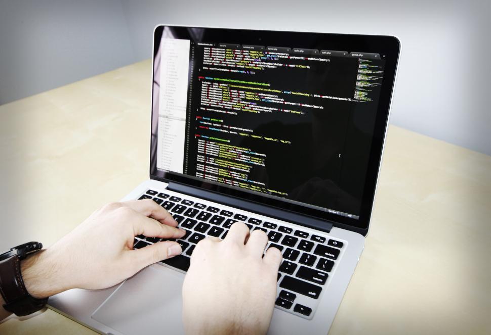 Free Image of Person coding on laptop with code on screen 
