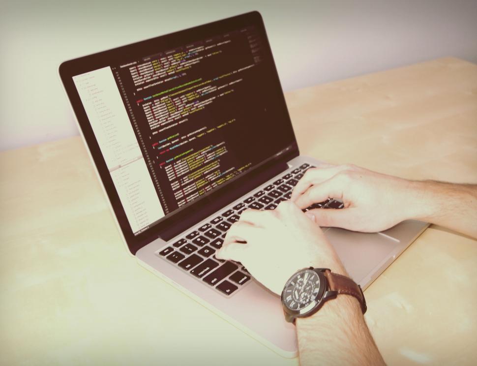 Free Image of Person coding on a laptop with watch 