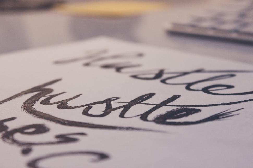 Free Image of Handwritten quote hustle on textured paper 