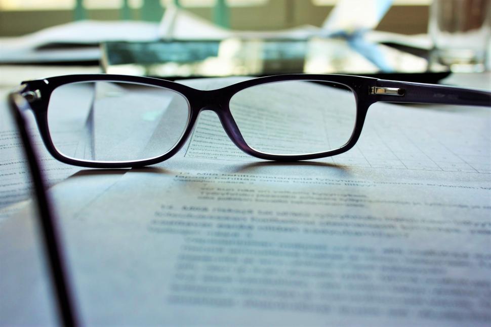 Free Image of Eyeglasses focusing on text on a document 