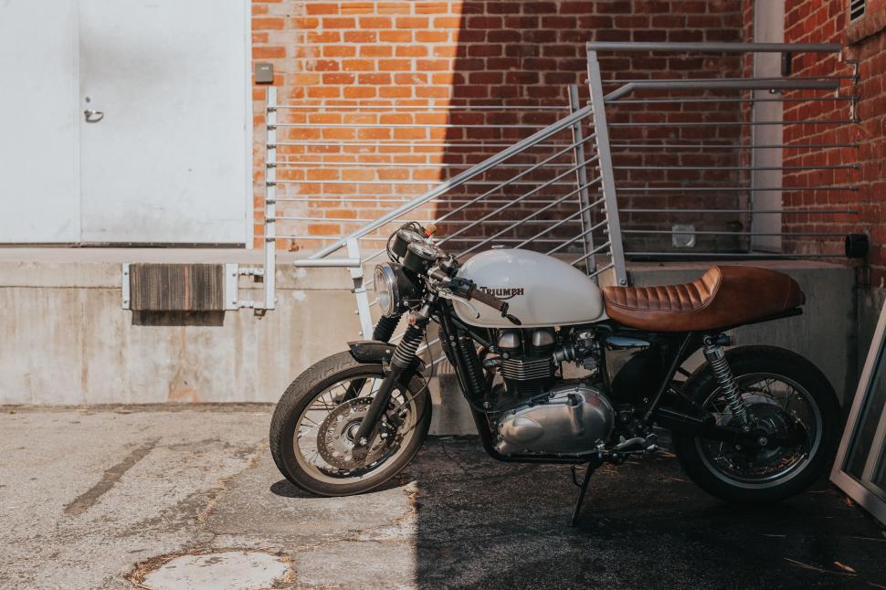Free Image of Vintage motorcycle parked by a wall 