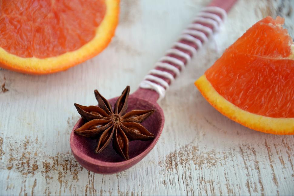 Free Image of Orange slice and star anise on a wooden spoon 