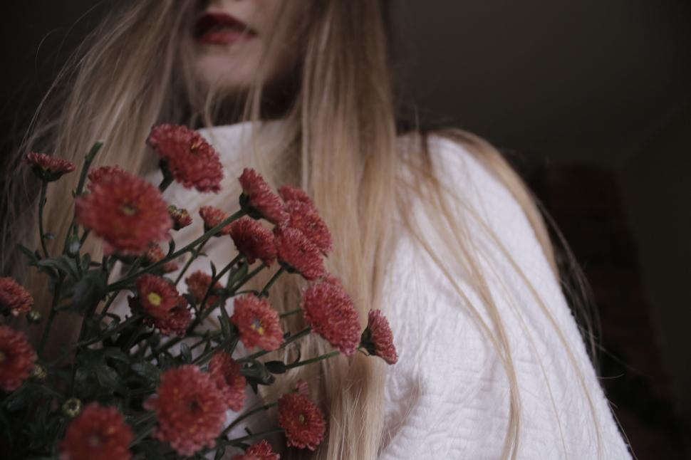 Free Image of Mysterious woman holding chrysanthemums 