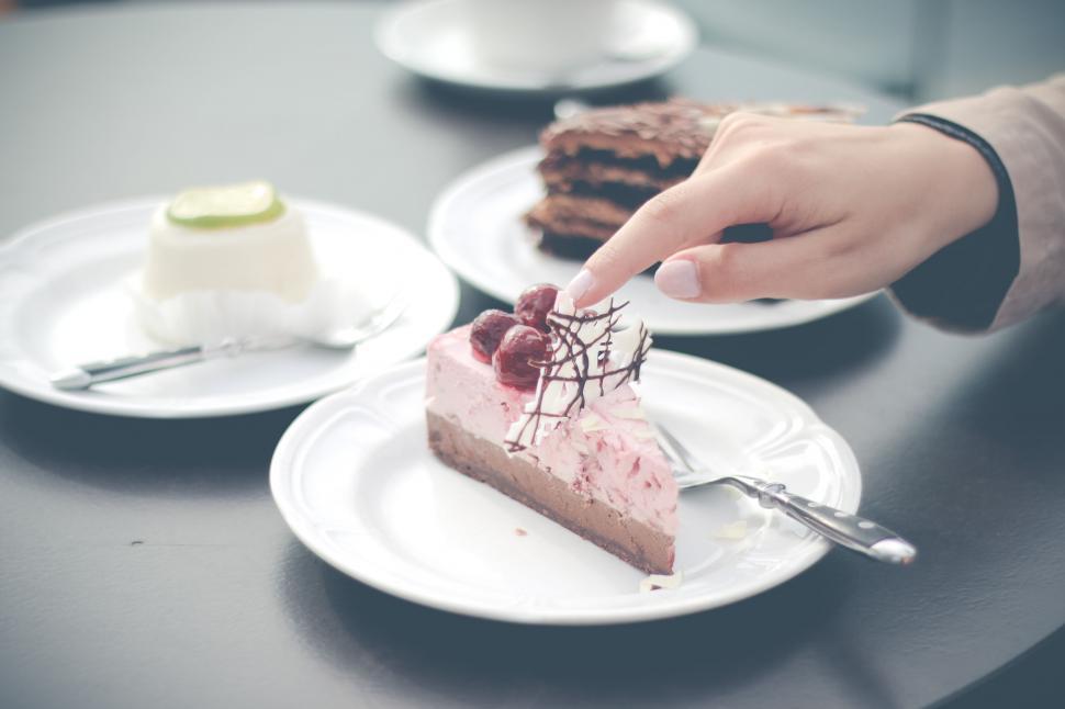 Free Image of Hand presenting a slice of berry cheesecake 