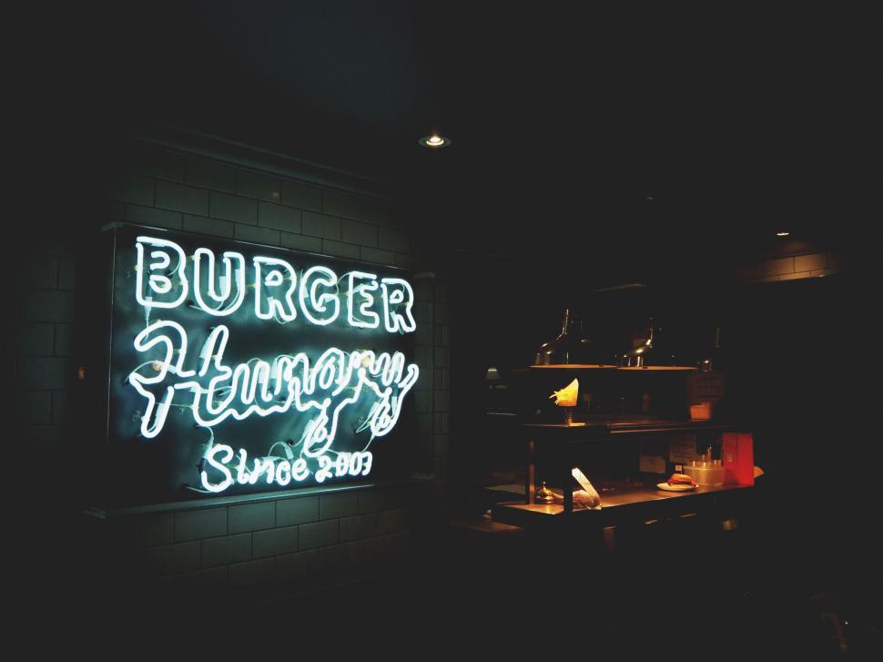Free Image of Neon  Burger Hungry  sign in a dark diner setting 