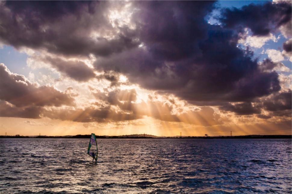 Free Image of Windsurfer on water under a dramatic sky 