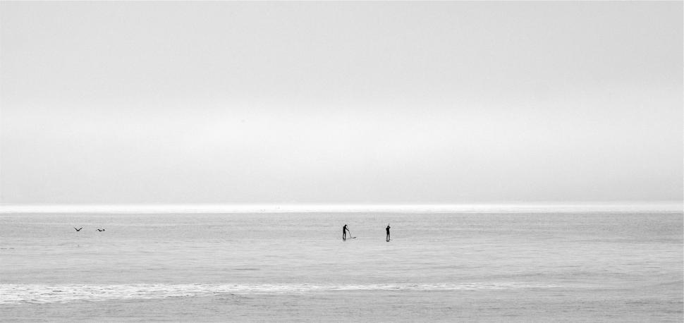 Free Image of Two people paddleboarding in misty waters 
