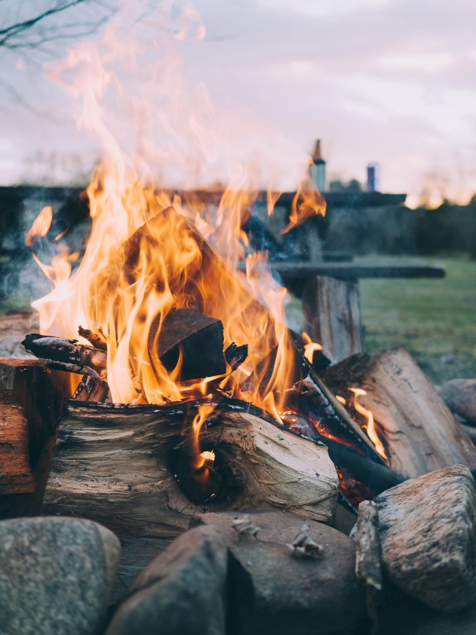 Free Image of Crackling campfire with rocks and wood logs 