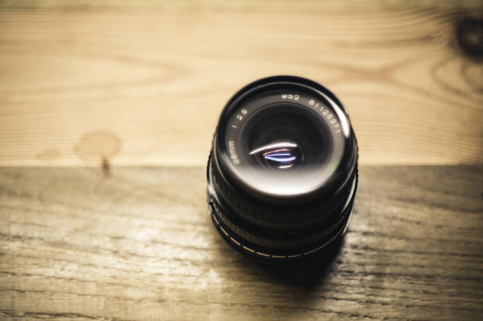 Free Image of Close-up of a camera lens on a wooden surface 