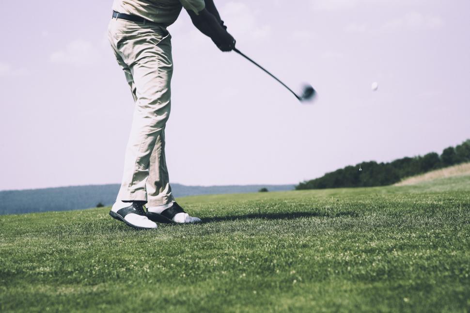 Free Image of Golfer mid-swing on a lush green course 