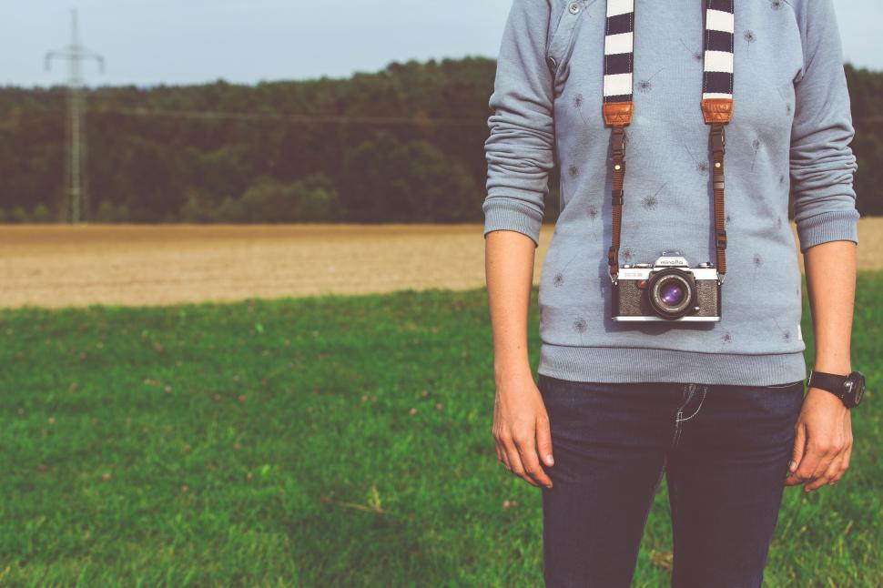 Free Image of Person with vintage camera around neck in field 