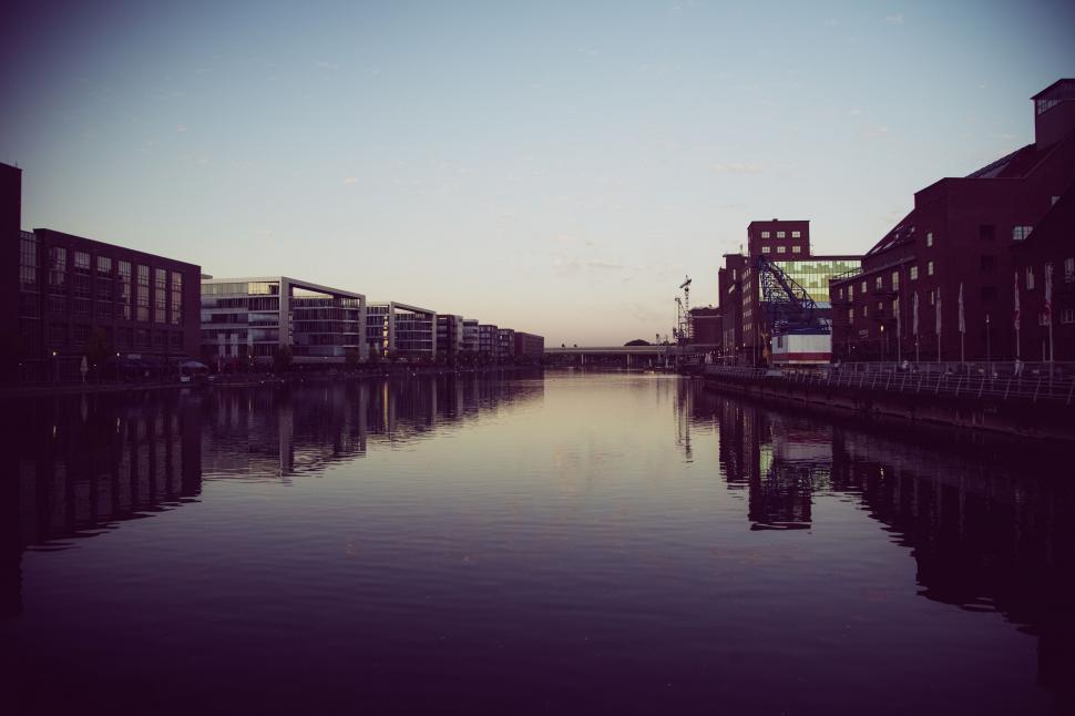 Free Image of Calm canal view at dusk with buildings 