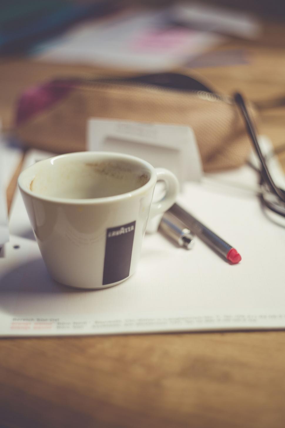 Free Image of Empty coffee cup on a cluttered desk 