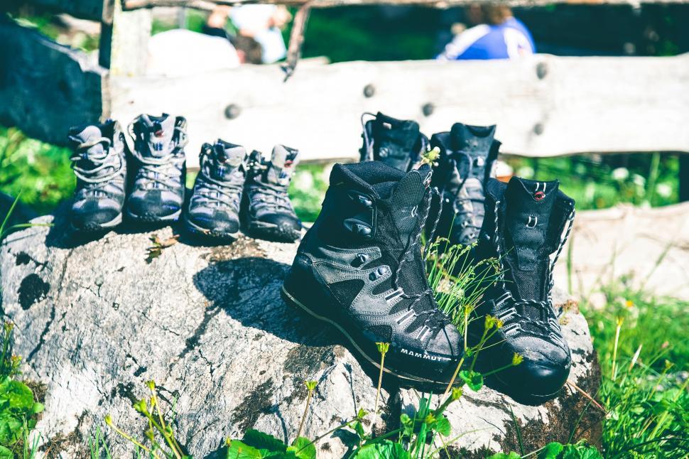Free Image of Hiking boots displayed on a rustic wooden fence 