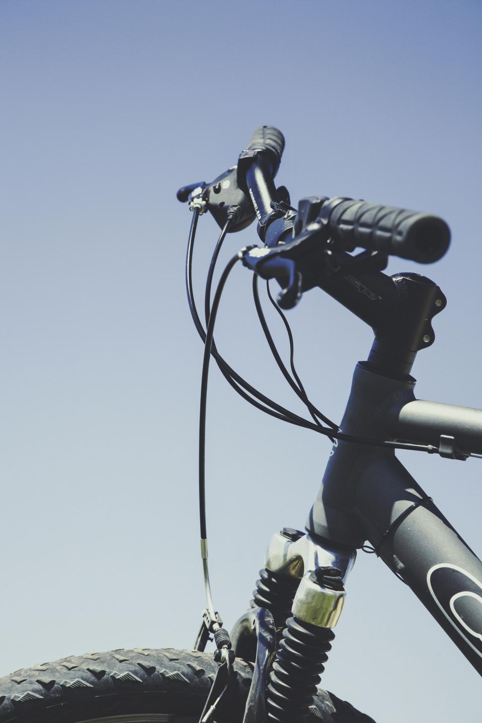 Free Image of Mountain bike handlebar against a blue sky 