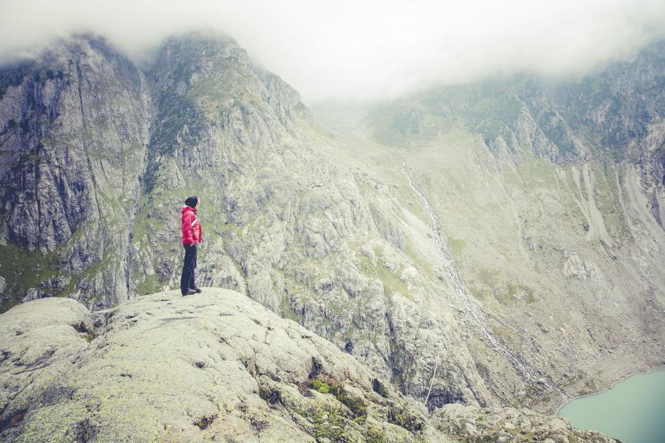 Free Image of Hiker gazing at mountain range in mist 
