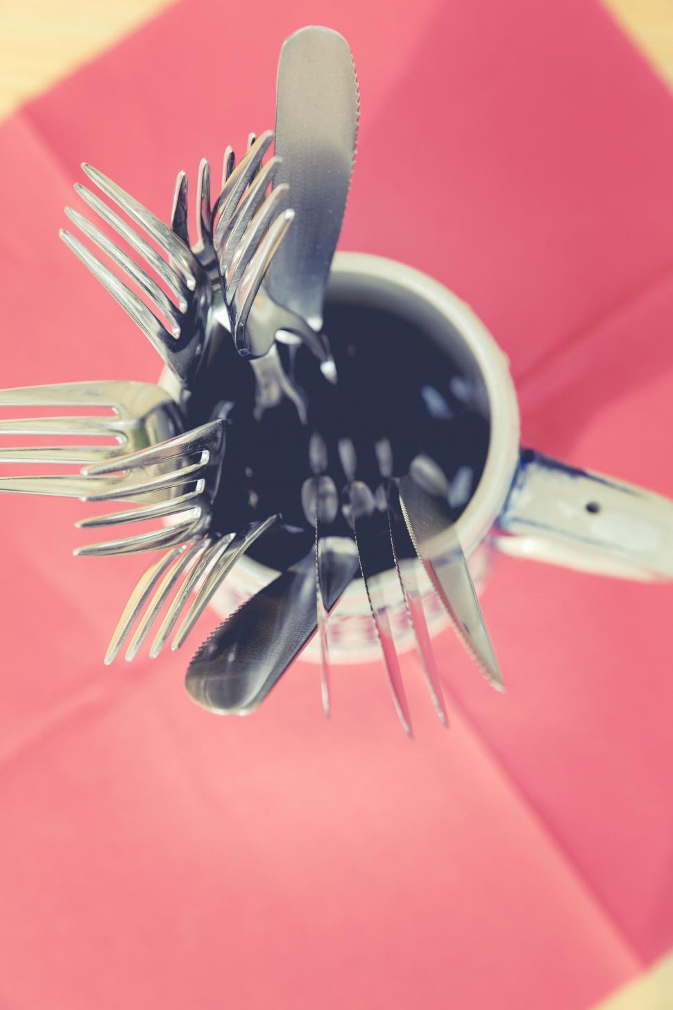 Free Image of Cutlery organized in a cup on a red napkin 
