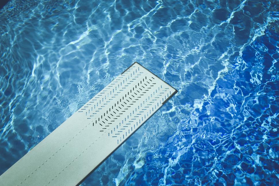 Free Image of Swimming pool diving board over blue water 