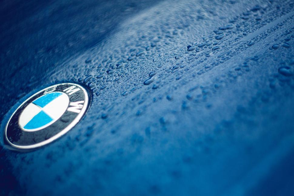 Free Image of BMW logo on wet blue vehicle surface 