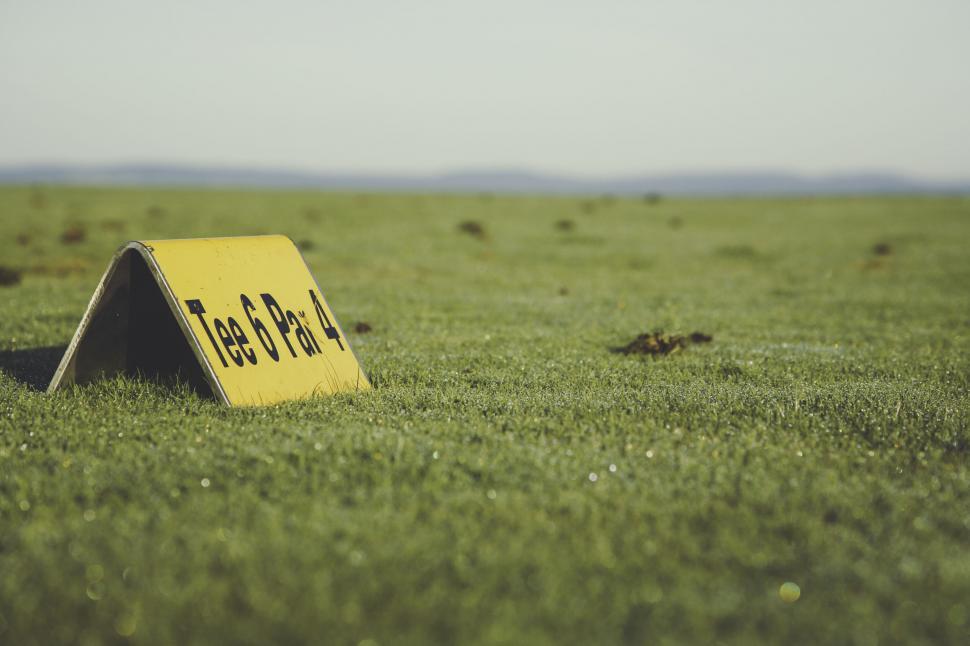 Free Image of Yellow sign on green field under blue sky 