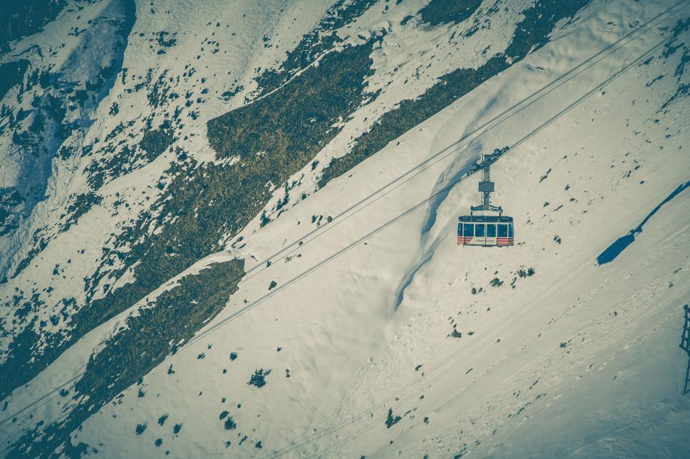 Free Image of Aerial view of a cable car over snowy mountains 
