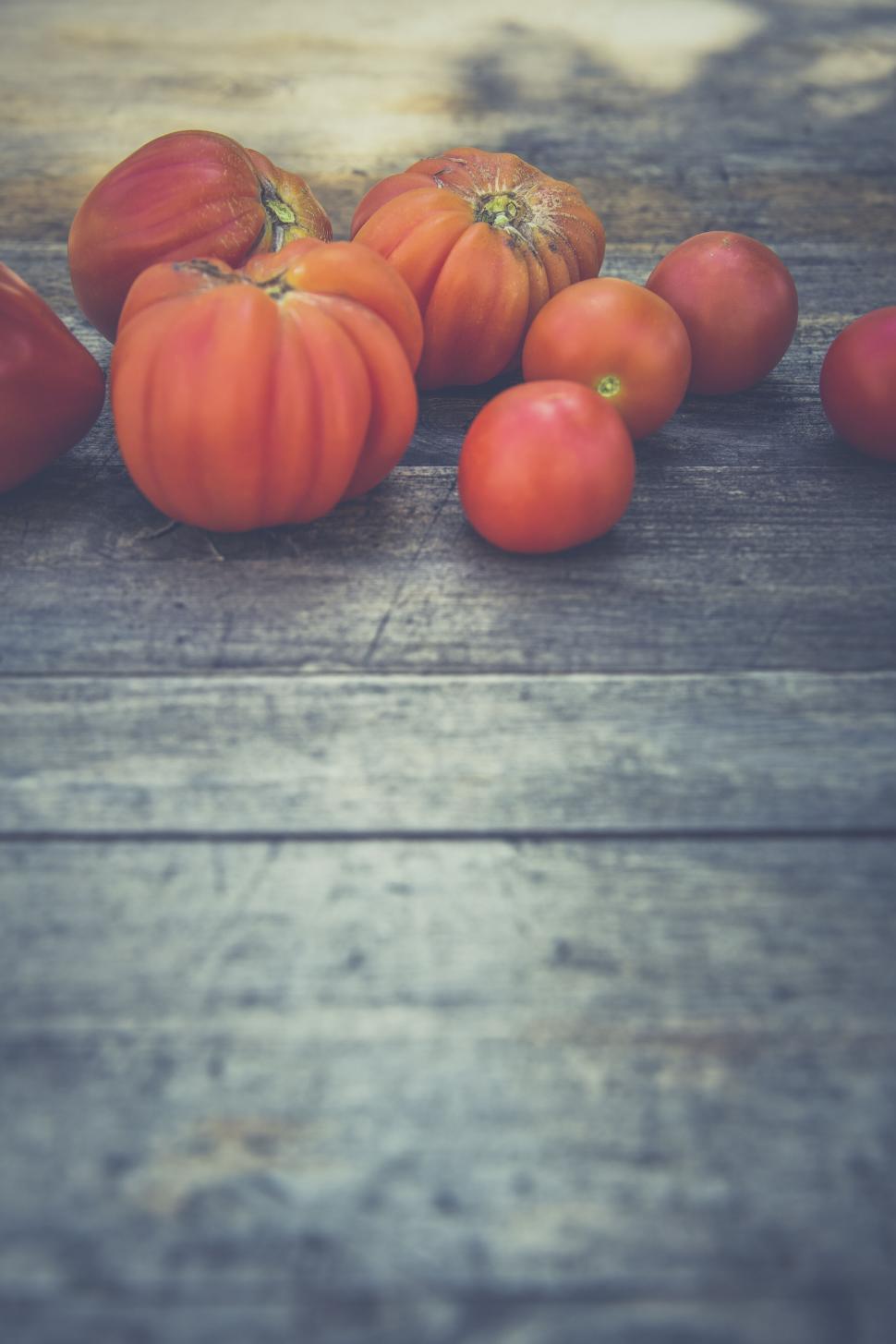 Free Image of Fresh heirloom tomatoes on rustic wooden table 