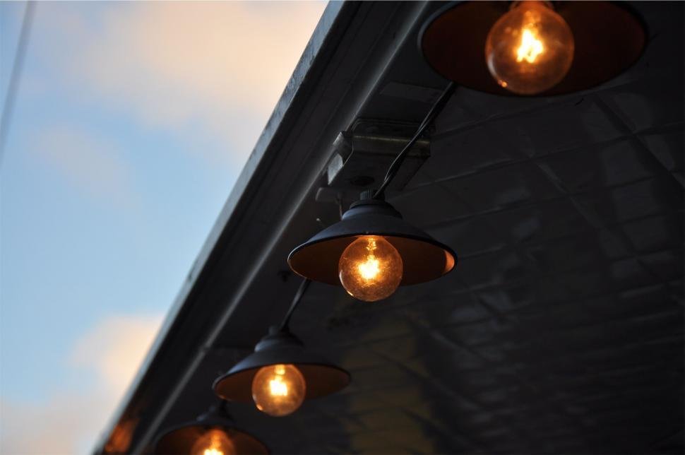 Free Image of Row of hanging lights against a twilight sky 