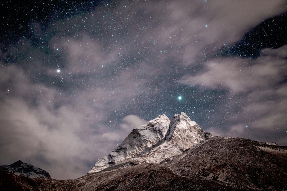 Free Image of Starry night over snowy mountain peak 
