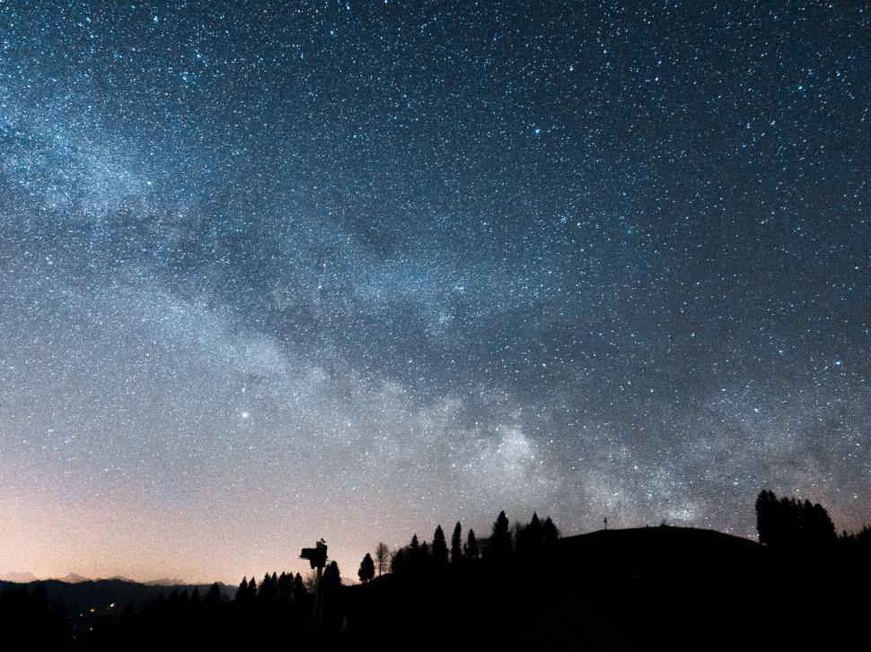 Free Image of Starry sky above silhouetted mountain range 
