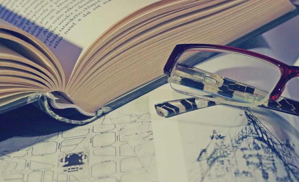 Free Image of Open book with glasses and architectural sketch 