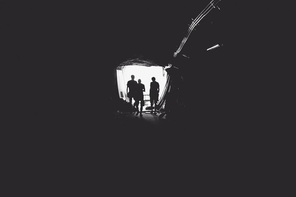 Free Image of Silhouetted figures walking out of the tunnel 