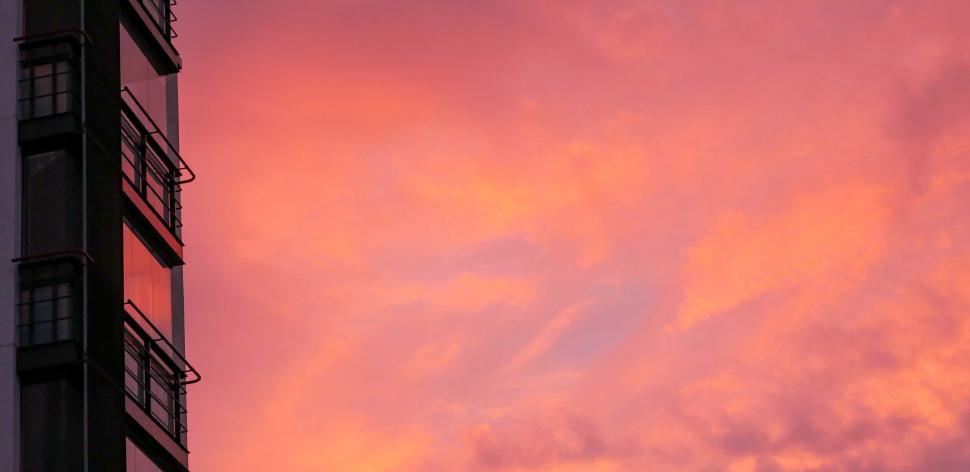 Free Image of Pink sunset hues behind urban building 
