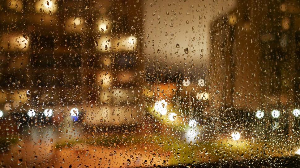 Free Image of Raindrops on window with city night lights 