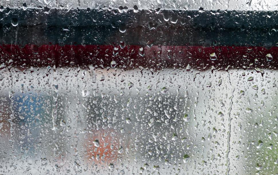 Free Image of Water droplets on a window with blurred background 