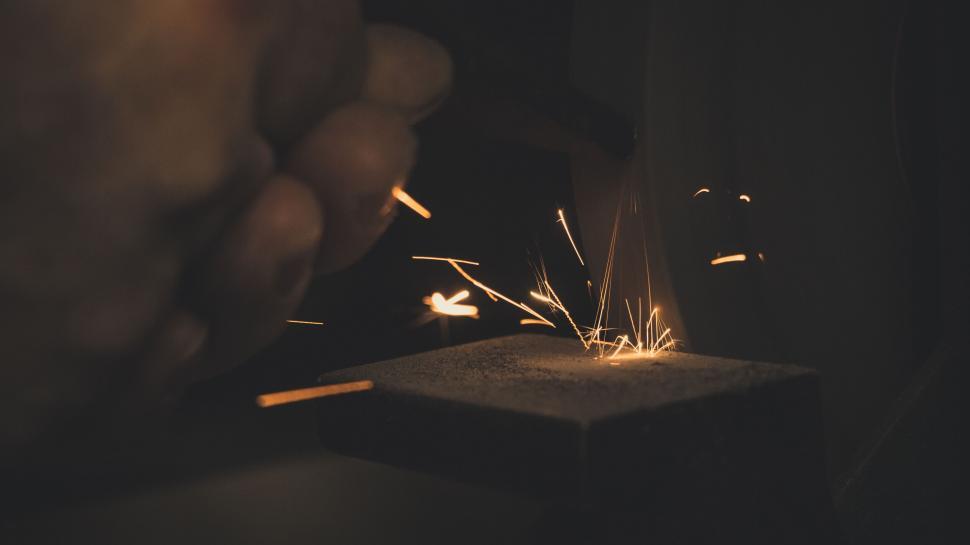 Free Image of Sparks flying from a striking match in the dark 