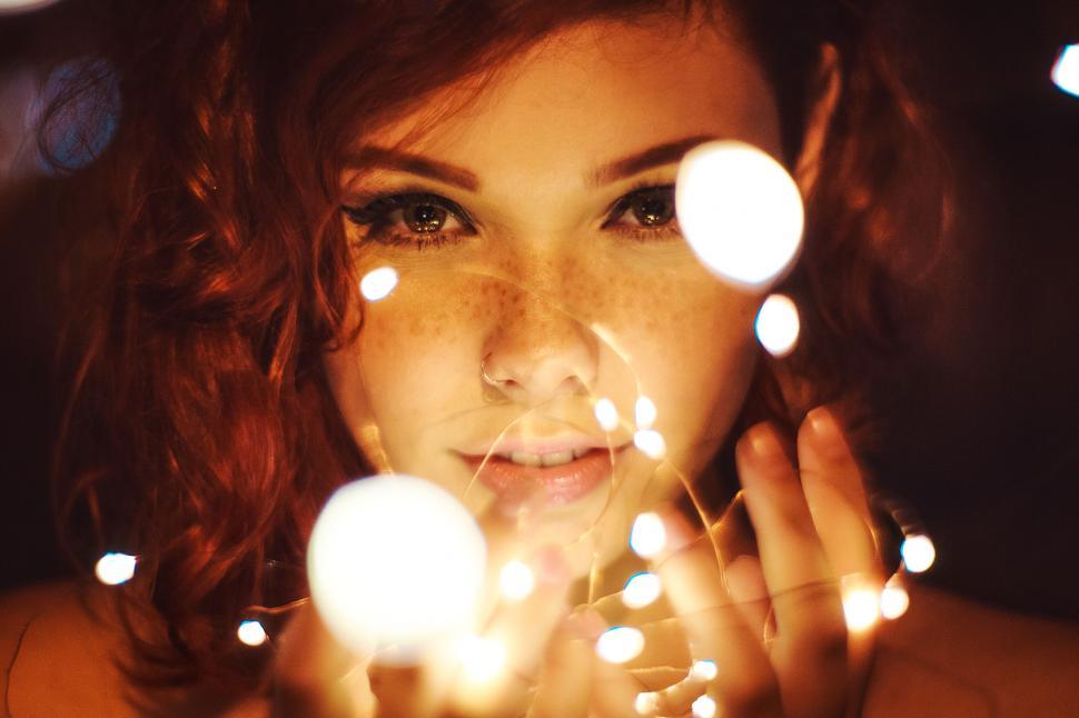 Free Image of Woman holding lights with a warm smile 